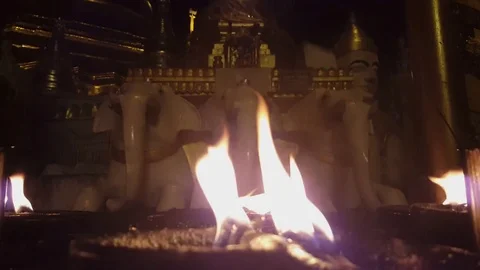 Closeup of candle flames, Buddhist statue of three elephants, Shwedagon Pagoda Видео 78069557