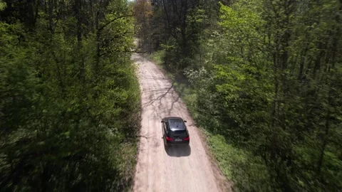Closeup of car driving in forest drone footage Video stock 240868990