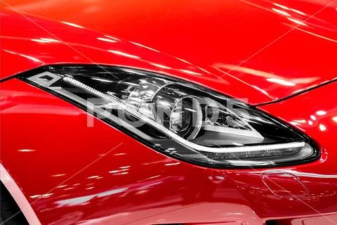 Closeup of car headlight in night. The front lights of the red sports car. Ca Stock Photos
