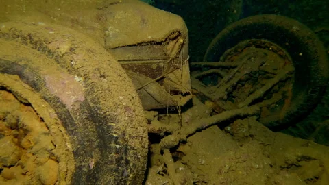 Closeup of car lying with its wheels up in luggage compartment of sunken ship Stock Footage 327559912