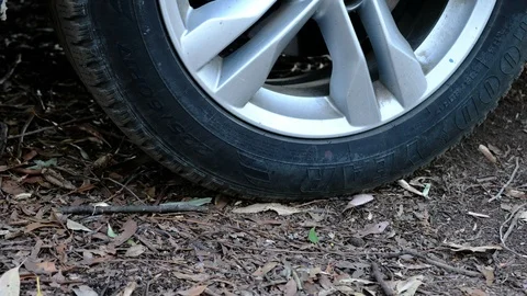 Closeup up of car tyre as it back off dirt driveway. Stock Footage 93729760
