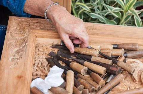 Closeup of a carpenter hands working with a chisel and hammer on wooden workb Stock Photos
