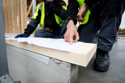 Closeup Of Carpenter Pointing On Plan By Colleague At Site 写真素材