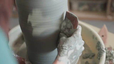 Closeup caucasian hands shaping clay cylinder on wheel with sponge smoothing rim Stock Footage 342282721