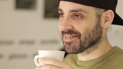 Closeup of caucasian man that drinks a cup of tea or coffee. Day light Stock Footage 149111353
