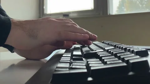 Closeup of caucasian man hands typing on a black keyboard on a white desk Stock Footage 142207752