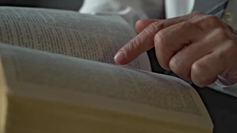 Closeup of Caucasian man's finger points on the holy bible and read it daytime Video stock 297377053
