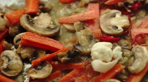 Closeup of cauliflower pieces falling onto sizzling stir-fry with mushrooms a Stock Footage 68752969