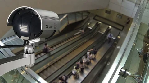 Closeup CCTV security camera operating with escalator system and people Vídeo Stock 81572389