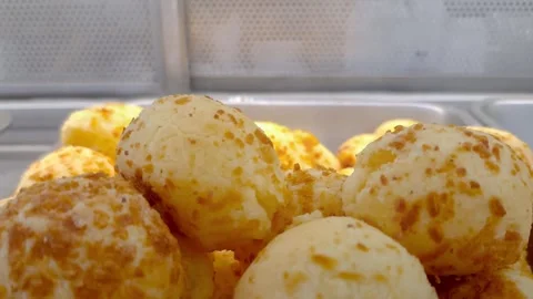 Closeup of cheese puffs steaming in the window of a Brazilian bakery. Stock Footage 332235119