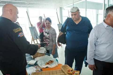 Closeup chef in black uniform serving snacks on table for degustation in Lviv Stock Photos