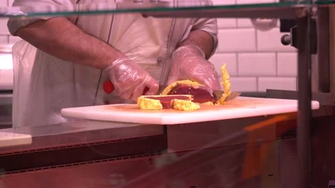 Closeup of chef cutting beef into slices with knife on cutting board Stock Footage 168643967