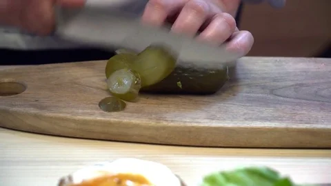 Closeup of chef cutting pickles for the hamburger Video stock 77042579