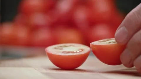 Closeup of chef cutting ripe red tomatoes with knife on cutting board in kitchen Stock Footage 253961463