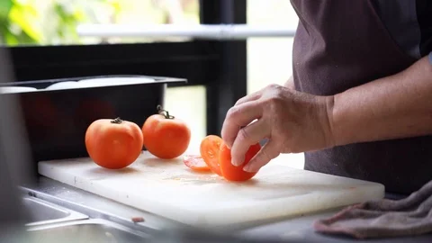 Closeup chef hand cutting tomato preparing for cooking, slow-motion Stock Footage 122195484