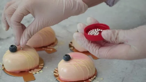 Closeup, chef hand decorates with silver beads cake with blueberry in the form Stock Footage 148832262