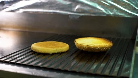 Closeup chef hand turning burger buns with sesame grilled on ridge surface Stock Footage 113605304