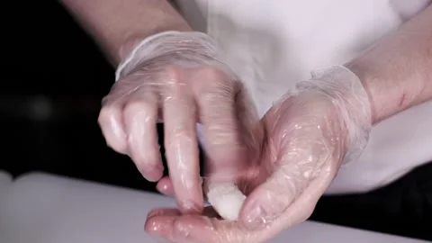 Closeup of the chef hands in gloves makes Japanese sushi rolls. Slow motion Stock Footage 133654516