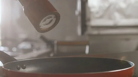 Closeup chef peppers dish in slow motion over frying pan. Stock Footage 113743646