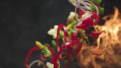 Closeup of chef preparing and throwing vegetable mix on frying pan on fire Stock Footage 266061394