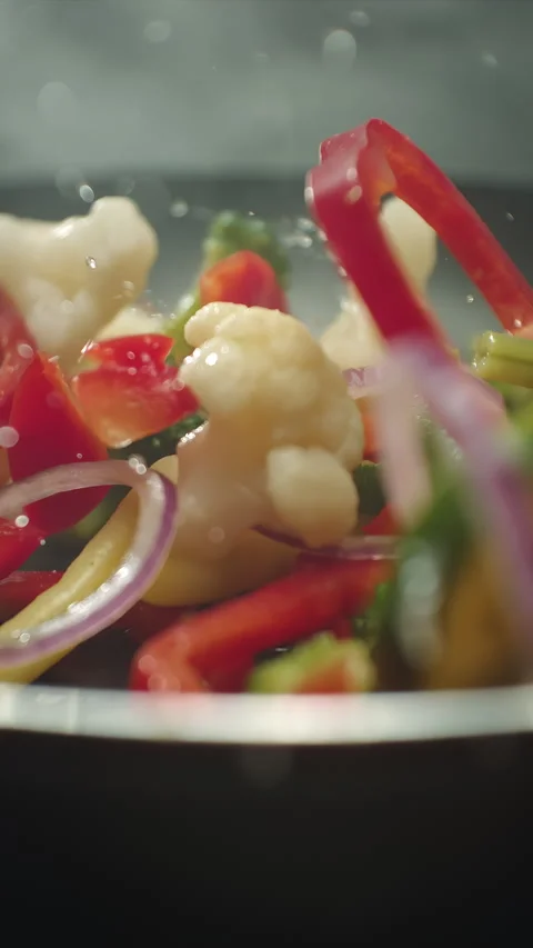 Closeup of chef preparing and throwing vegetable mix on frying pan. Preparation Stock Footage 308456051