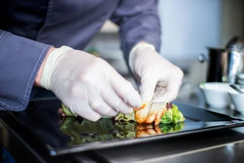Closeup chef preparing salad with eel cucumbers and lettuce leaves on mat Stock Photos