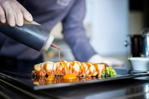 Closeup chef preparing salad with eel cucumbers and lettuce leaves on mat Stock Photos