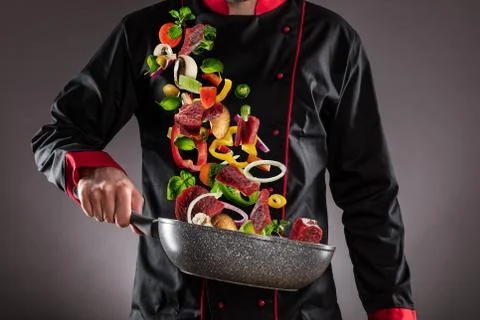 Closeup of chef throwing beef meat with vegetable Foto stock