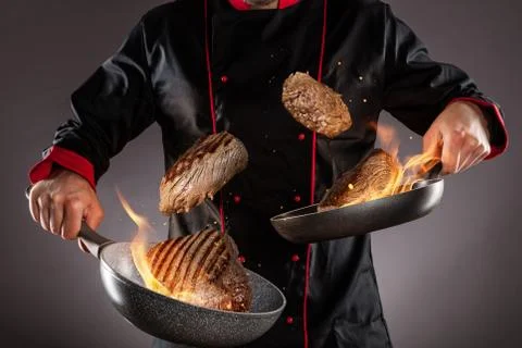 Closeup of chef throwing beef steaks into the air Stock Photos