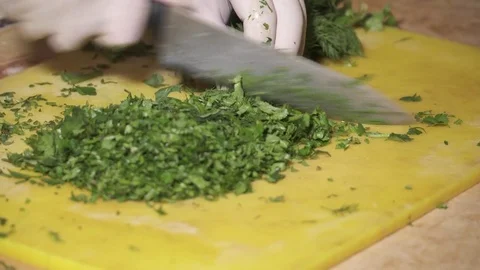 CLoseup of chef's hands chopping fresh dill with knife Stock Footage 73624072