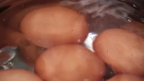 Closeup chicken brown eggs are boiled in a metal saucepan in boiling water. Video stock 262065609
