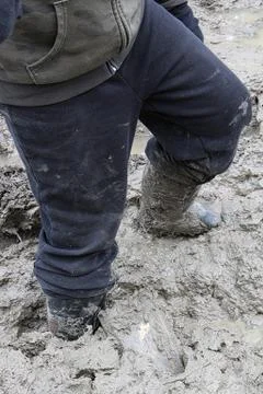 Closeup of a child walking in thick mud Stock Photos