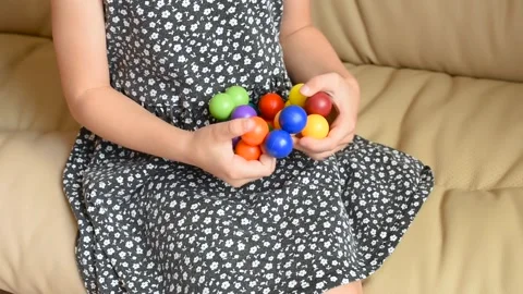 Closeup of children's hands with logic puzzle game with colorful balls Stock Footage 318795504