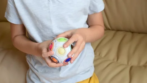Closeup of children's hands with logic puzzle game with colorful balls 스톡 동영상 318795510