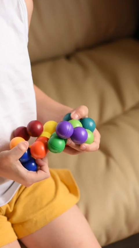 Closeup of children's hands with logic puzzle game with colorful balls Video stock 318795531