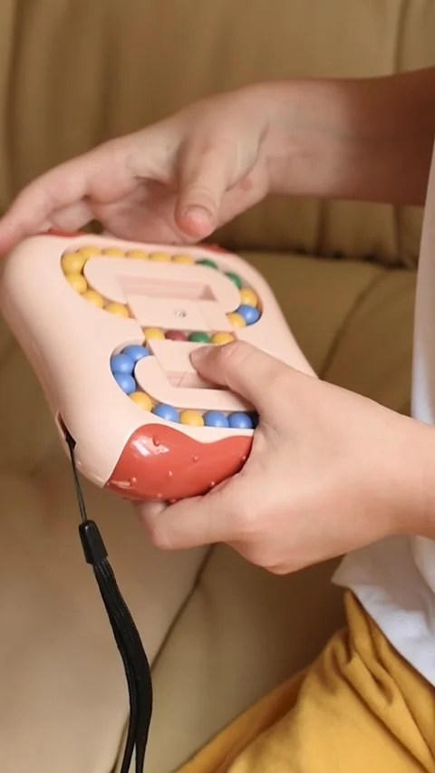 Closeup of children's hands with logic puzzle game with colorful balls Stockbeeldmateriaal 318795533