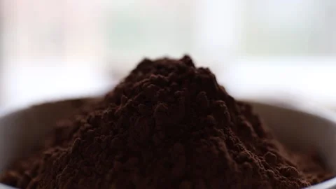 Closeup on choccolate falling on cocoa powder in backlight Stock Footage 130252946