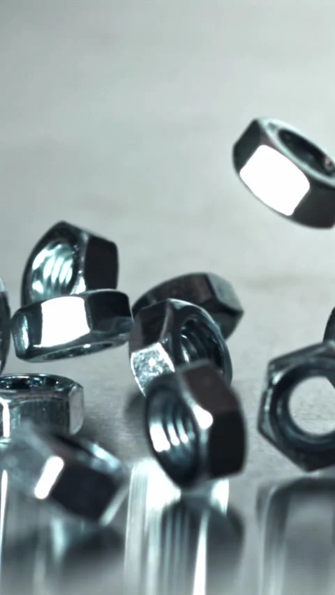 Closeup of chrome nuts hitting reflective table during product testing Filmed on Video stock 335395606