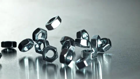 Closeup of chrome nuts hitting reflective table during product testing Filmed on Stock Footage 335412077