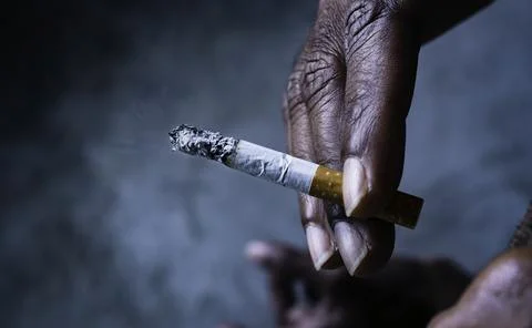 Closeup of cigarette butt with hand Stock Photos