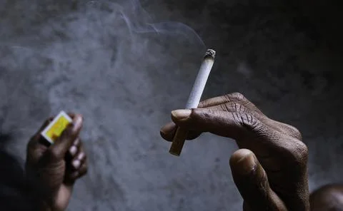 Closeup of cigarette butt with hand Photos