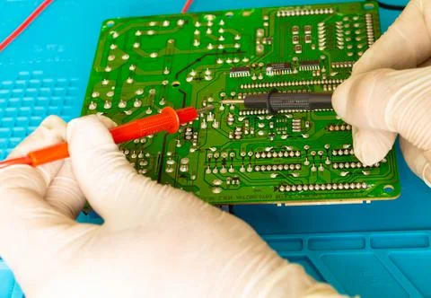 A closeup of a circuit board being checked by an engineer using a test head c Stock Photos