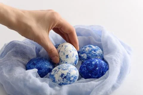 Closeup classic blue eggs with gradient effect in textile nest for Easter on Stock Photos