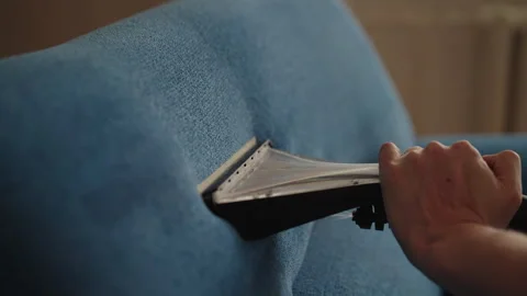 Closeup of cleaning service worker removing stain from blue sofa using wet Stock Footage 313715214