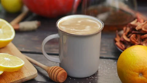 Closeup cocoa drink in mug with white sugar falling in drink and female hand Stock Footage 237515045