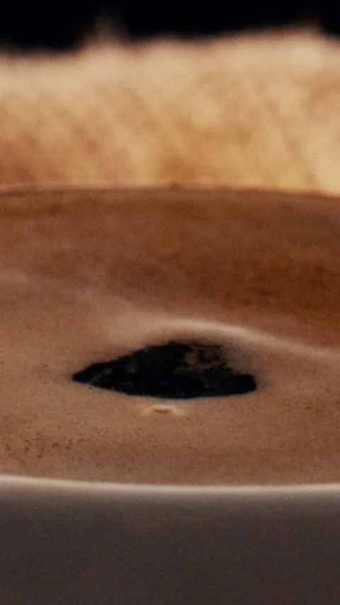 Closeup, coffee and drop in cup with ripple, warm drink and caffeine in latte Stock Footage 340458858