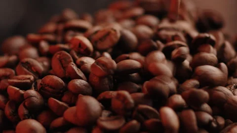 Closeup coffee beans fall into a grinder cup. Brown fresh seeds pouring super Stock Footage 245980994