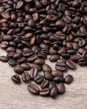 Closeup of coffee beans over rustic wooden table Stock Photos