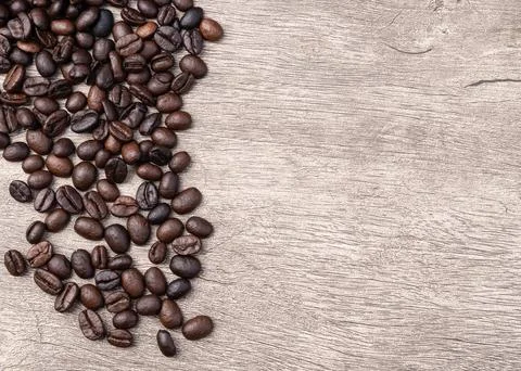 Closeup of coffee beans over rustic wooden table with copy space Stock Photos