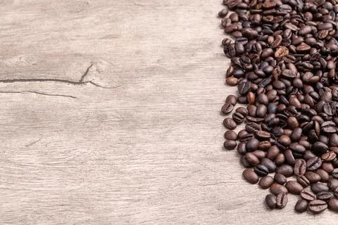Closeup of coffee beans over rustic wooden table with copy space Stock Photos
